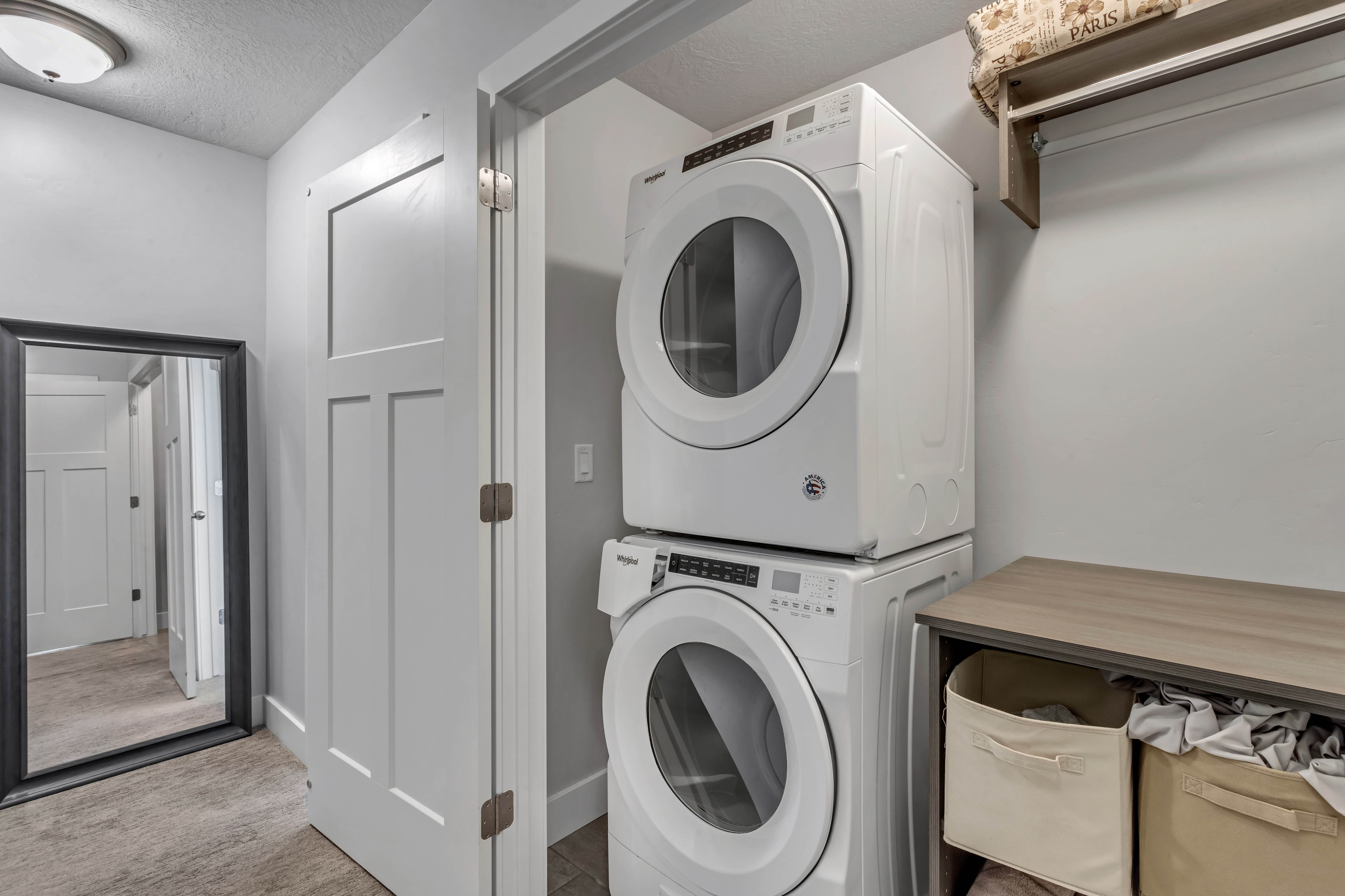 Laundry area featuring stacked washer and clothes dryer and a textured ceiling