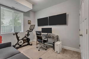 Bedroom/Office room with light colored carpet and baseboards