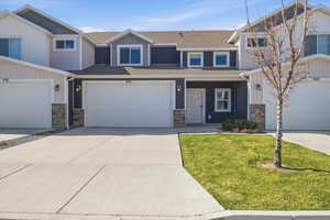 Craftsman inspired home featuring stone siding, roof with shingles, concrete driveway, and a porch