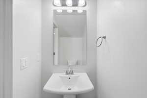 Downstairs Half bath featuring a sink and toilet