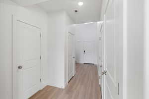 Hallway featuring light wood-type flooring and baseboards