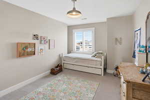 Bedroom featuring baseboards and light carpet