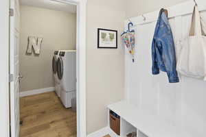 Laundry room featuring light wood-style flooring and independent washer and dryer
