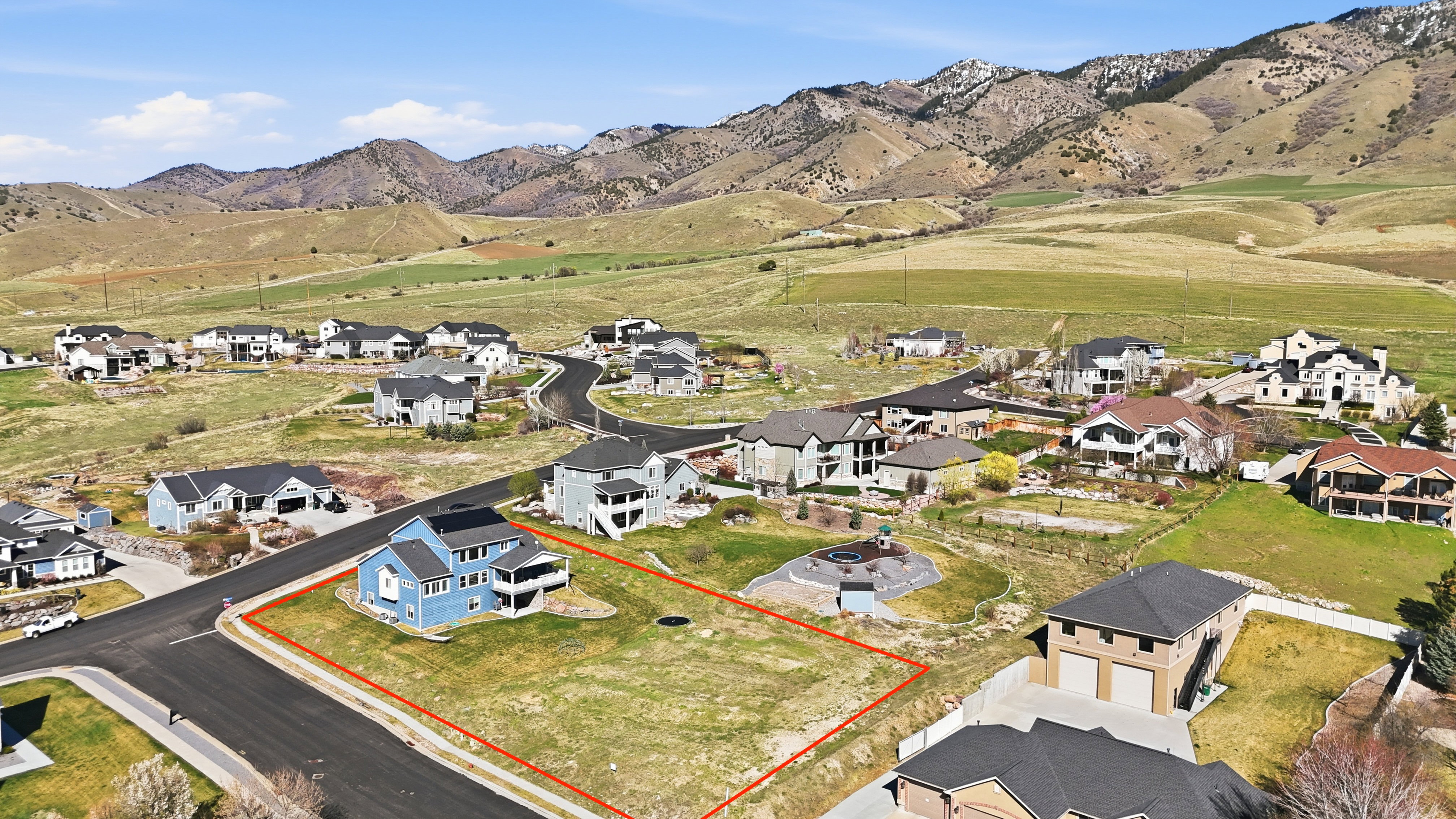 Expansive land parcel outlined in red, featuring a paved road frontage