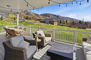 Wooden deck with a mountain view, a lawn, and outdoor lounge area