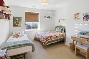 Bedroom featuring light carpet and baseboards