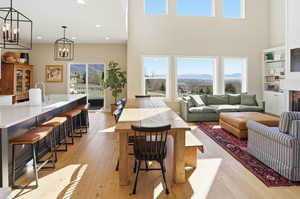 Living area with light wood-style flooring, a fireplace, and hanging lights
