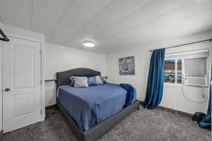 Bedroom featuring carpet flooring, a textured ceiling, and cooling unit