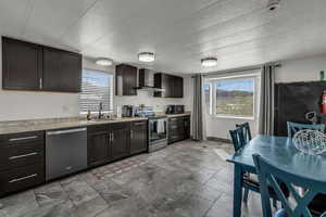 Kitchen with stainless steel appliances, light countertops, dark wood finish cabinetry, and a textured ceiling