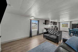 Living area with a textured ceiling and light wood-style flooring