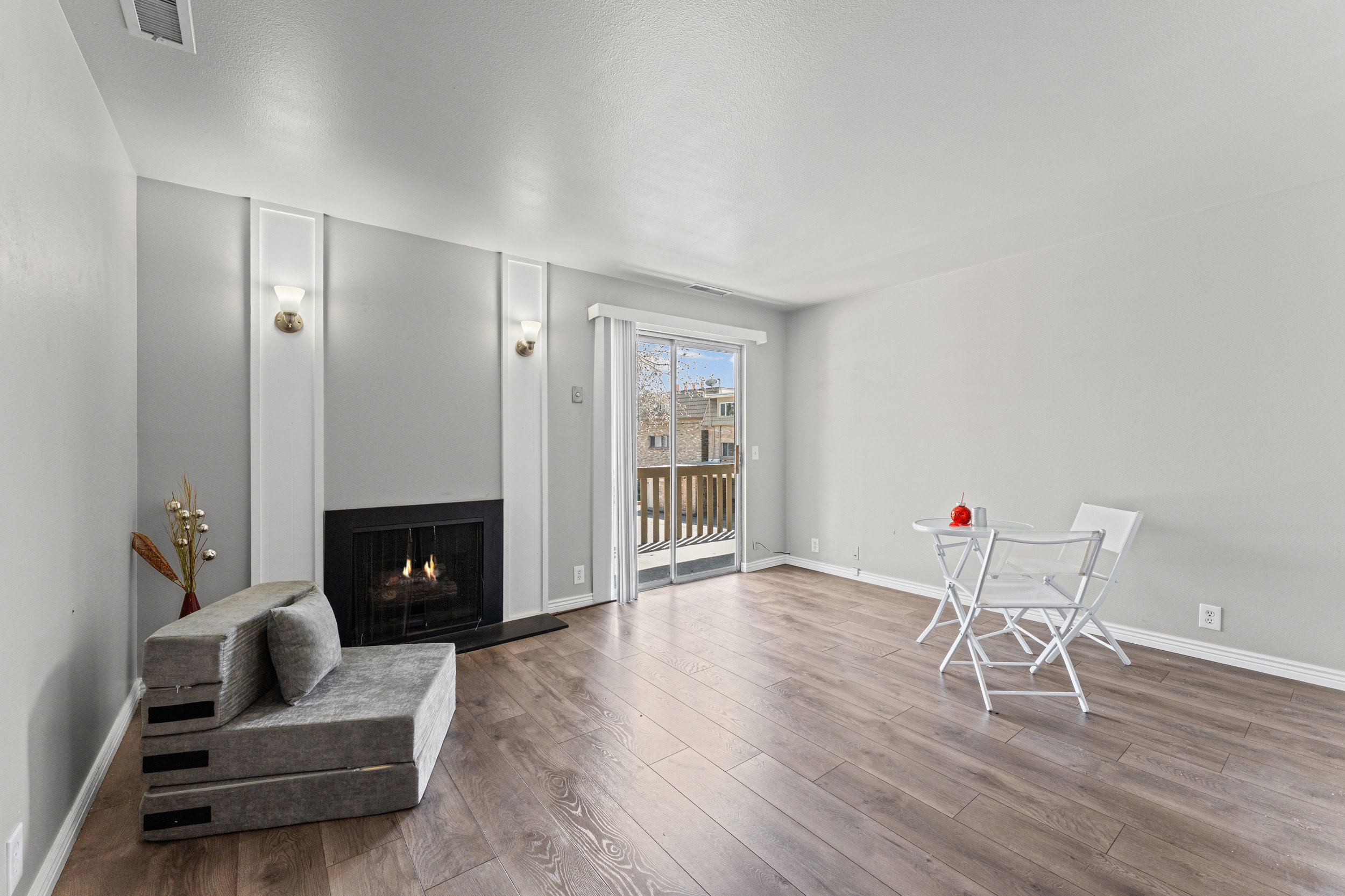 Living area with a warm lit fireplace and wood-type flooring