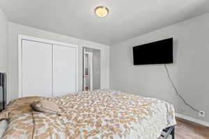Bedroom featuring light wood-style floors and a closet