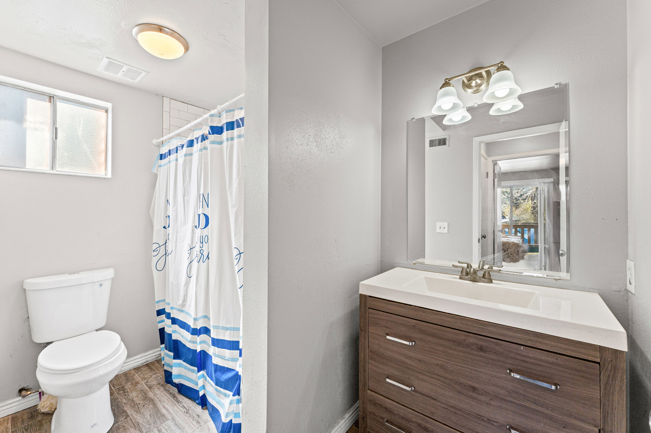 Bathroom featuring vanity, a shower with shower curtain, and light wood finished floors