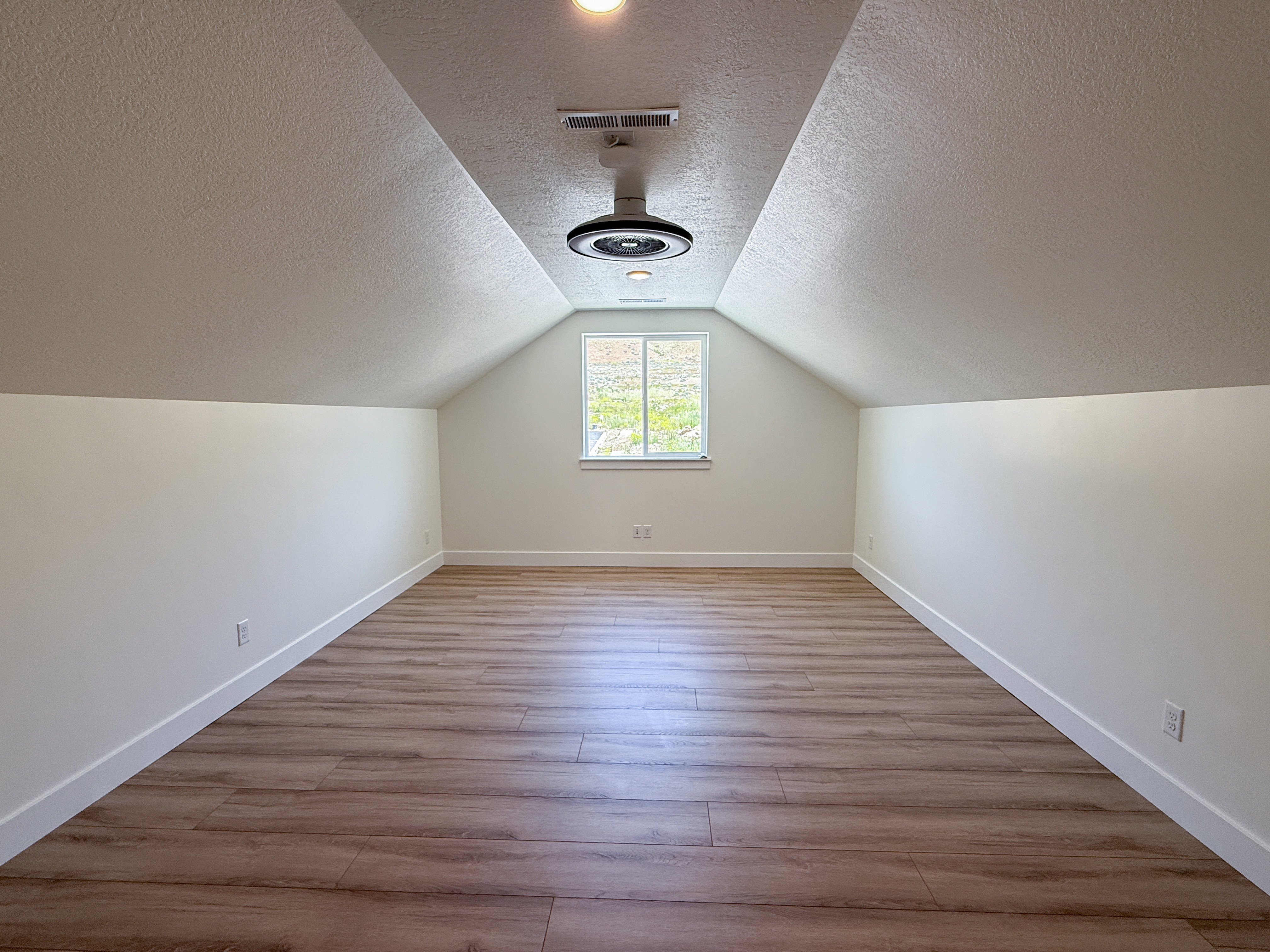 Additional living space with light wood-type flooring and a textured ceiling