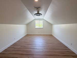 Additional living space with light wood-type flooring and a textured ceiling