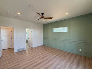 Unfurnished bedroom featuring a decorative wall, recessed lighting, light wood-style floors, ceiling fan, and connected bathroom