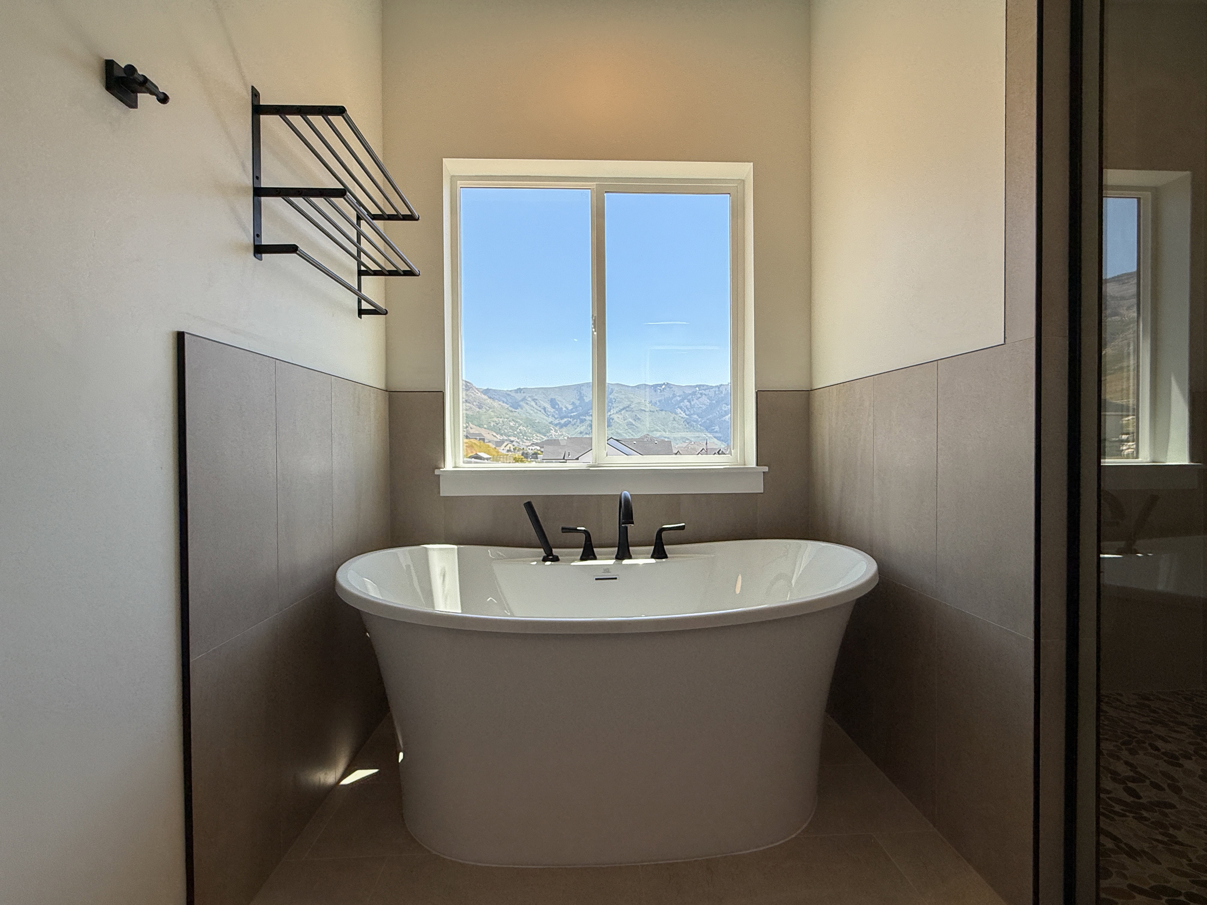Full bath with a soaking tub, tile patterned flooring, and wainscoting