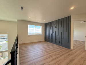Unfurnished bedroom with light wood-style floors, a textured ceiling, and recessed lighting