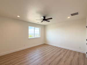 Unfurnished room featuring light wood-type flooring, a textured ceiling, ceiling fan, and recessed lighting