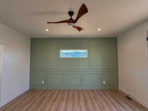 Unfurnished room with light wood finished floors, ceiling fan, a decorative wall, a textured ceiling, and recessed lighting