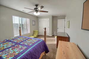Bedroom featuring light carpet, ceiling fan, and a closet