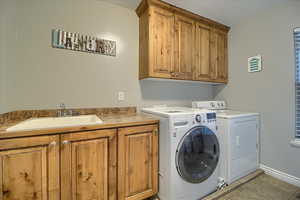 Laundry room with independent washer and dryer, cabinet space, and light tile patterned floors