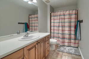 Full bathroom with vanity, a shower with curtain, and light tile patterned floors