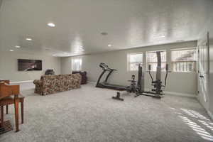 Exercise area featuring carpet flooring, a textured ceiling, and recessed lighting