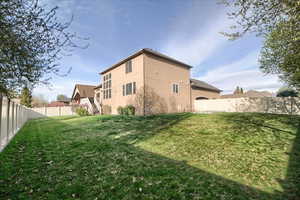 Back of house featuring a fenced backyard and stucco siding