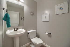 Half bath with toilet and baseboards