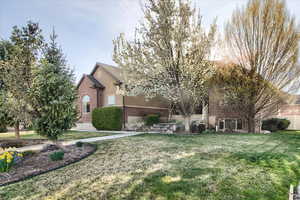 Obstructed view of property featuring brick siding and a front lawn