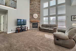 Living room with a high ceiling, a fireplace, and carpet