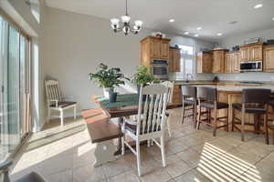 Dining space with hanging lights and light tile patterned floors