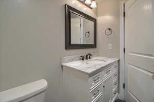 Half bathroom with vanity and toilet
