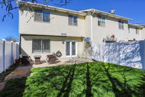 Back of property with a fenced backyard and a patio area