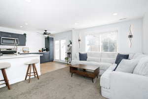 Living area with recessed lighting, ceiling fan, light carpet, and light tile patterned flooring