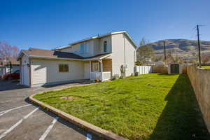 Back of property with a storage unit and a fenced backyard