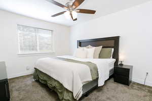 Bedroom with dark carpet and ceiling fan