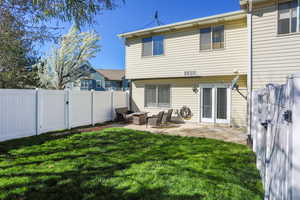 Rear view of house with a gate, a fenced backyard, and a patio area