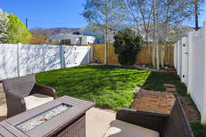 Fenced backyard featuring a patio, an outdoor fire pit, and a mountain view