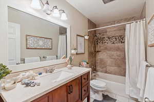 Bathroom with vanity, shower / bath combo, and light tile patterned flooring