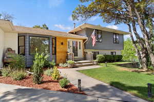 Tri-level home with a front yard and brick siding