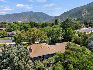 Bird's eye view of a mountain backdrop and a tree filled landscape
