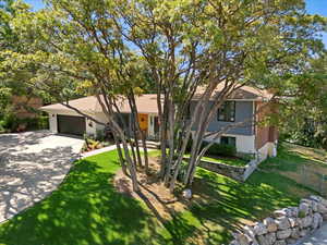 View of front of home featuring concrete driveway, an attached garage, and a front yard