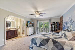 Bedroom featuring access to outside, light carpet, crown molding, a ceiling fan, and connected bathroom