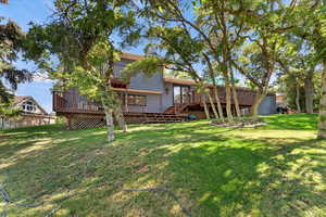 Back of property with a deck and a yard