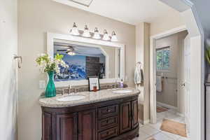 Bathroom featuring double vanity, ceiling fan, and light tile patterned floors