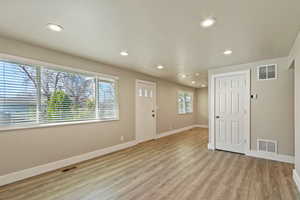 Entrance foyer with light wood finished floors and recessed lighting