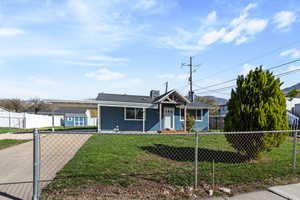 Ranch-style home featuring an attached carport and a fenced front yard