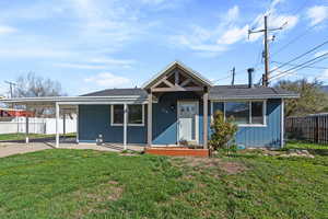 View of front of home featuring covered porch, a carport, and a shingled roof